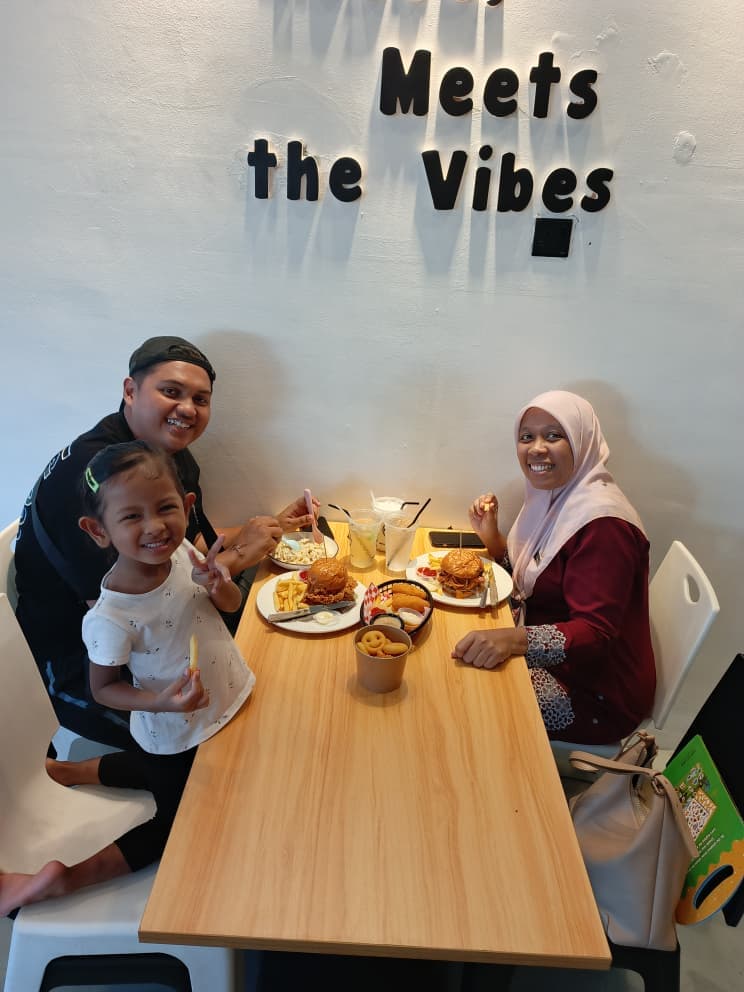 A family sharing burgers and sides at The Roadside Eatery